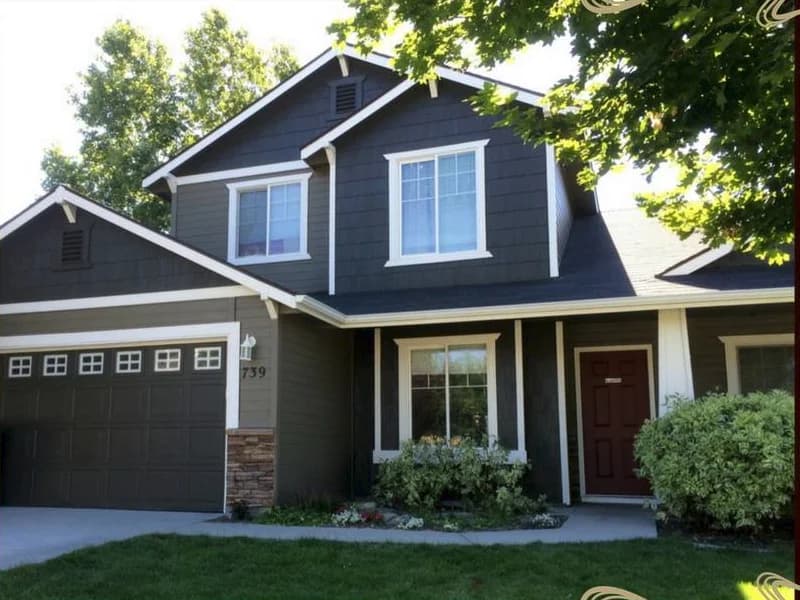 Two-story home exterior freshly painted in dark charcoal with white trim