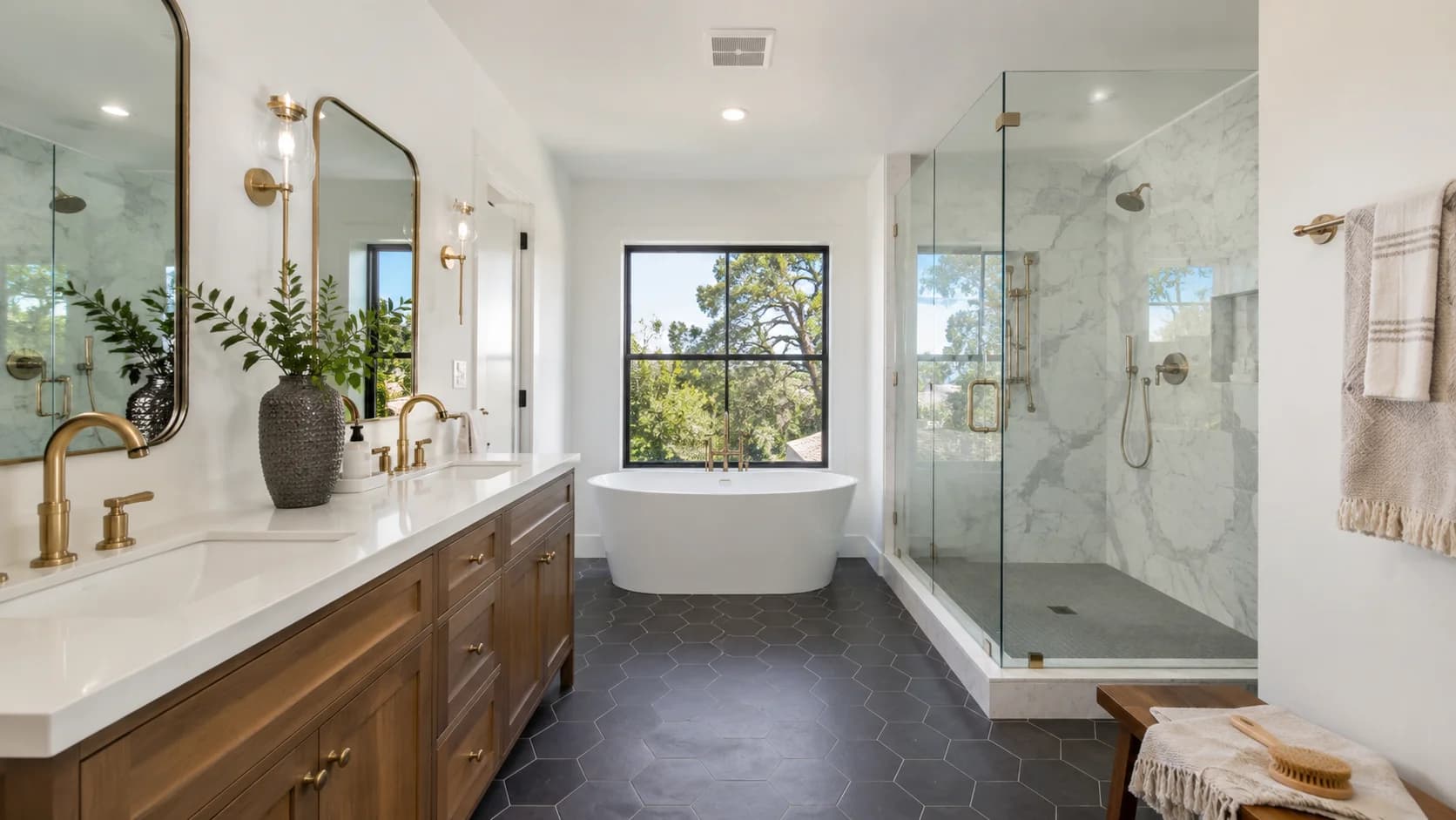 Remodeled bathroom with a double vanity, brass fixtures and hexagon tile flooring