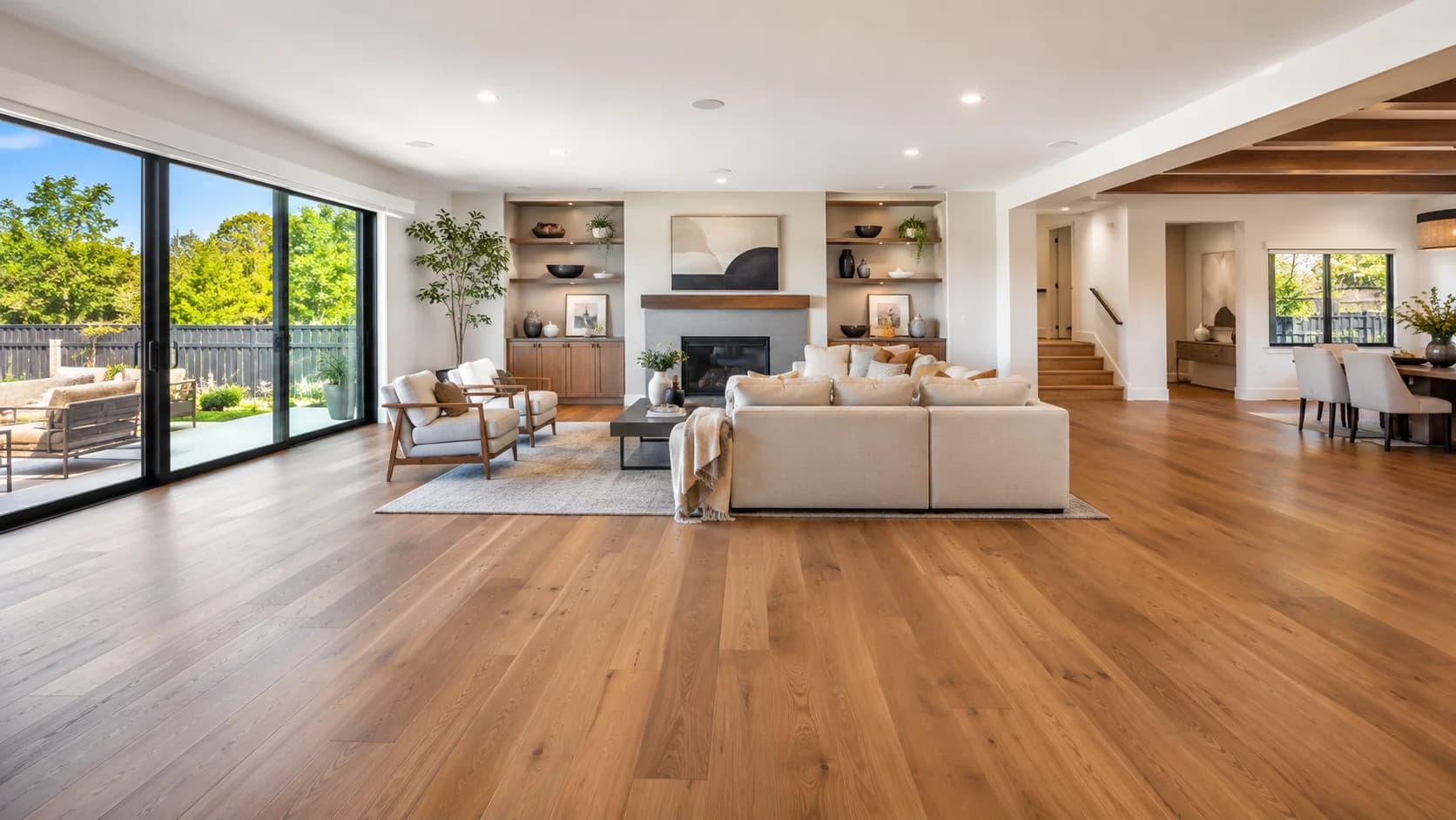 Finished interior with natural wood cabinetry and flooring, a quartz waterfall island and a copper sink